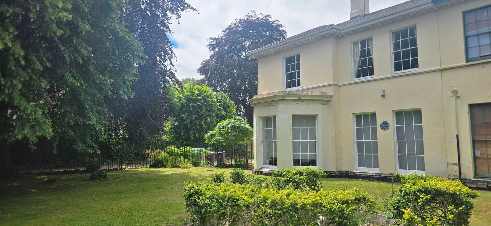 The front of Beechwood House — a cream-rendered period building with bay windows and mature gardens, home to Beechwood House Healthcare in Wolverhampton.